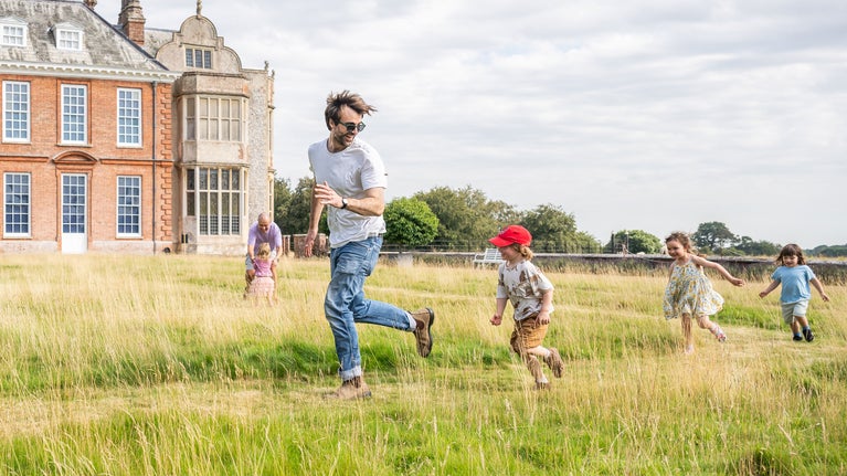 A family playing on the lawn in summer at Felbrigg Hall, Norfolk